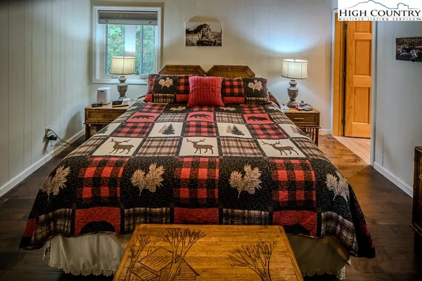 a bedroom with a bed and a lamp on dresser