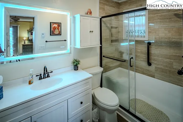 a bathroom with a sink a toilet and shower