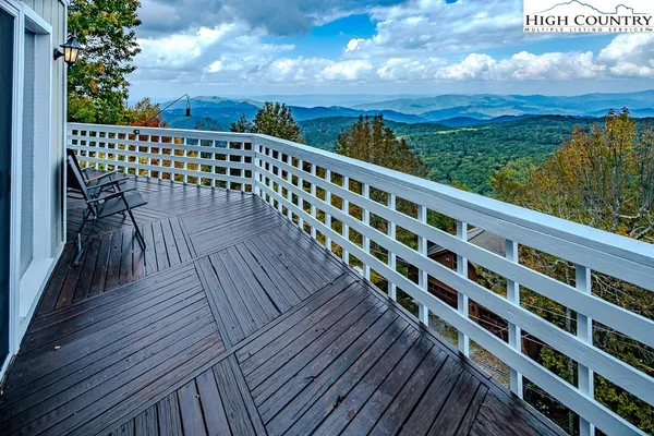 a view of a balcony with wooden floor & fence