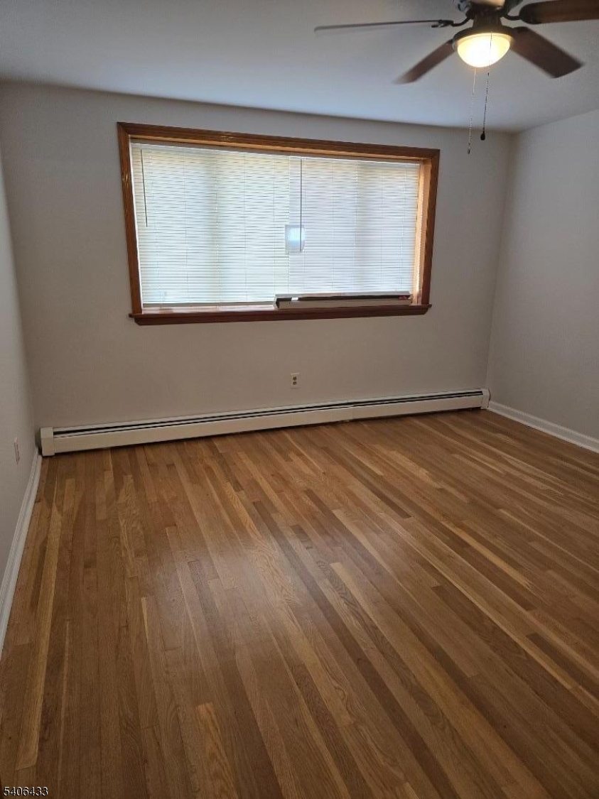 110 Elm Street Newark, NJ 07105 - Photo 7 of 11 an empty room with wooden floor and windows
