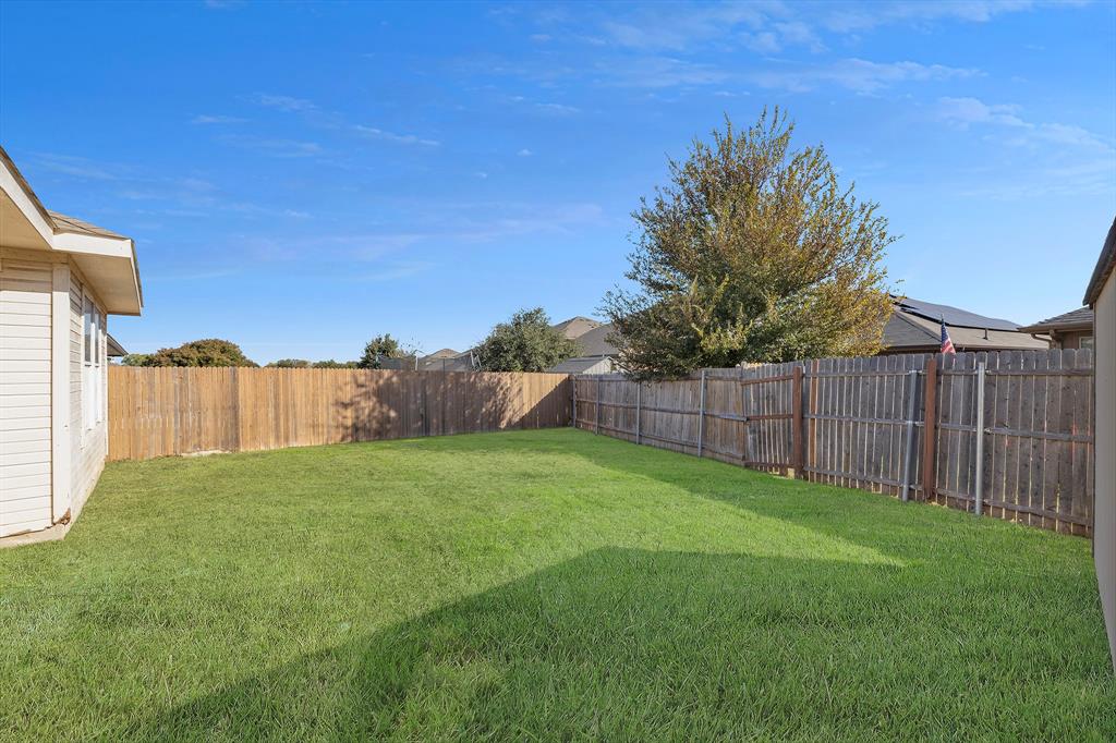 605 Clearbrook Street Azle, TX 76020 - Photo 30 of 33 Spacious backyard featuring a lush lawn, wood privacy fencing, and mature landscaping