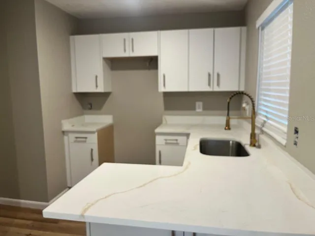 a kitchen with a sink a stove and cabinets