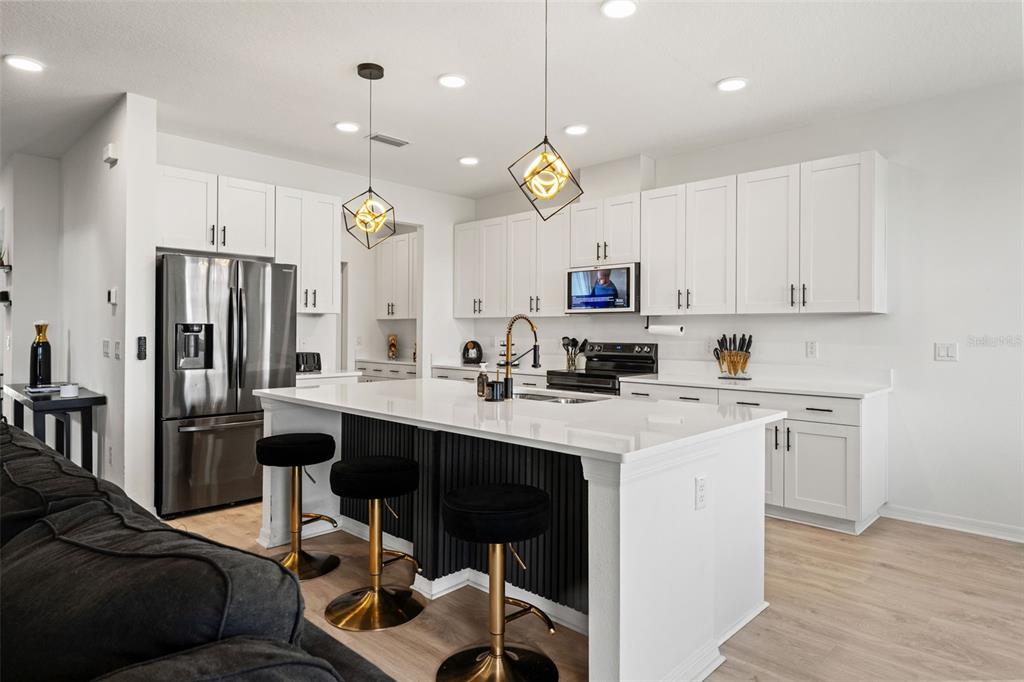 5945 Newberry Pnes Avenue Wesley Chapel, FL 33545 - Photo 19 of 55 a kitchen with a sink a center island a counter space stainless steel appliances and cabinets