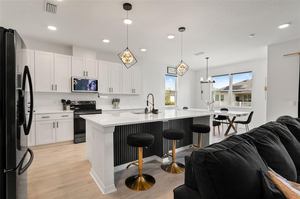 5945 Newberry Pnes Avenue Wesley Chapel, FL 33545 - Photo 21 of 55 a kitchen with stainless steel appliances kitchen island granite countertop a sink a stove a refrigerator and cabinets