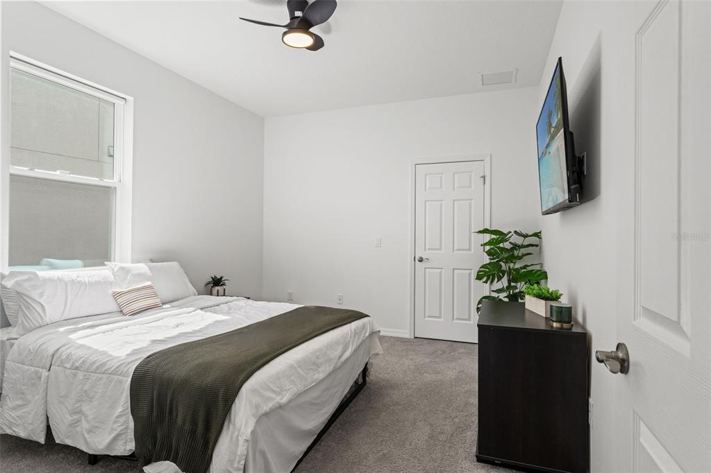 5945 Newberry Pnes Avenue Wesley Chapel, FL 33545 - Photo 25 of 55 a bedroom with a bed and a potted plant