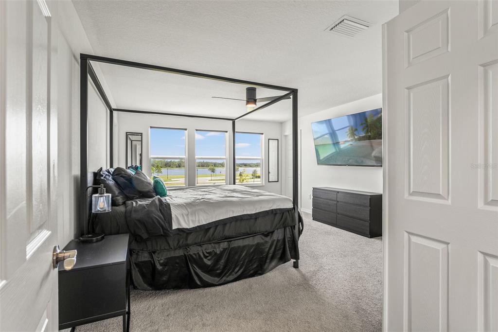 5945 Newberry Pnes Avenue Wesley Chapel, FL 33545 - Photo 31 of 55 a bedroom with a bed and a dresser next to a window