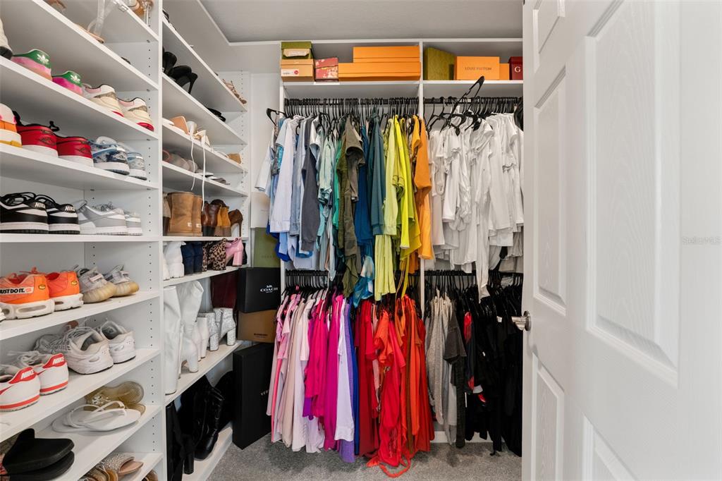 5945 Newberry Pnes Avenue Wesley Chapel, FL 33545 - Photo 33 of 55 a view of walk in closet with clothes and shoes