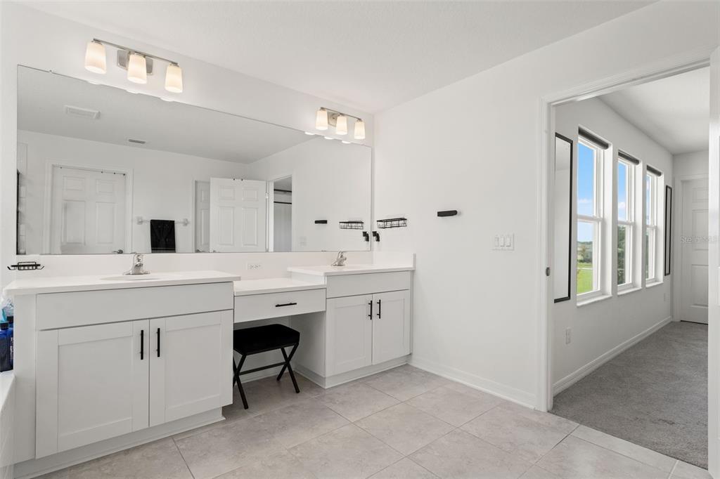 5945 Newberry Pnes Avenue Wesley Chapel, FL 33545 - Photo 35 of 55 a spacious bathroom with a sink a mirror and a vanity