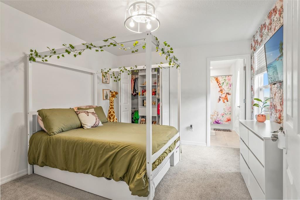 5945 Newberry Pnes Avenue Wesley Chapel, FL 33545 - Photo 37 of 55 a bedroom with a bed chandelier and painting on the wall