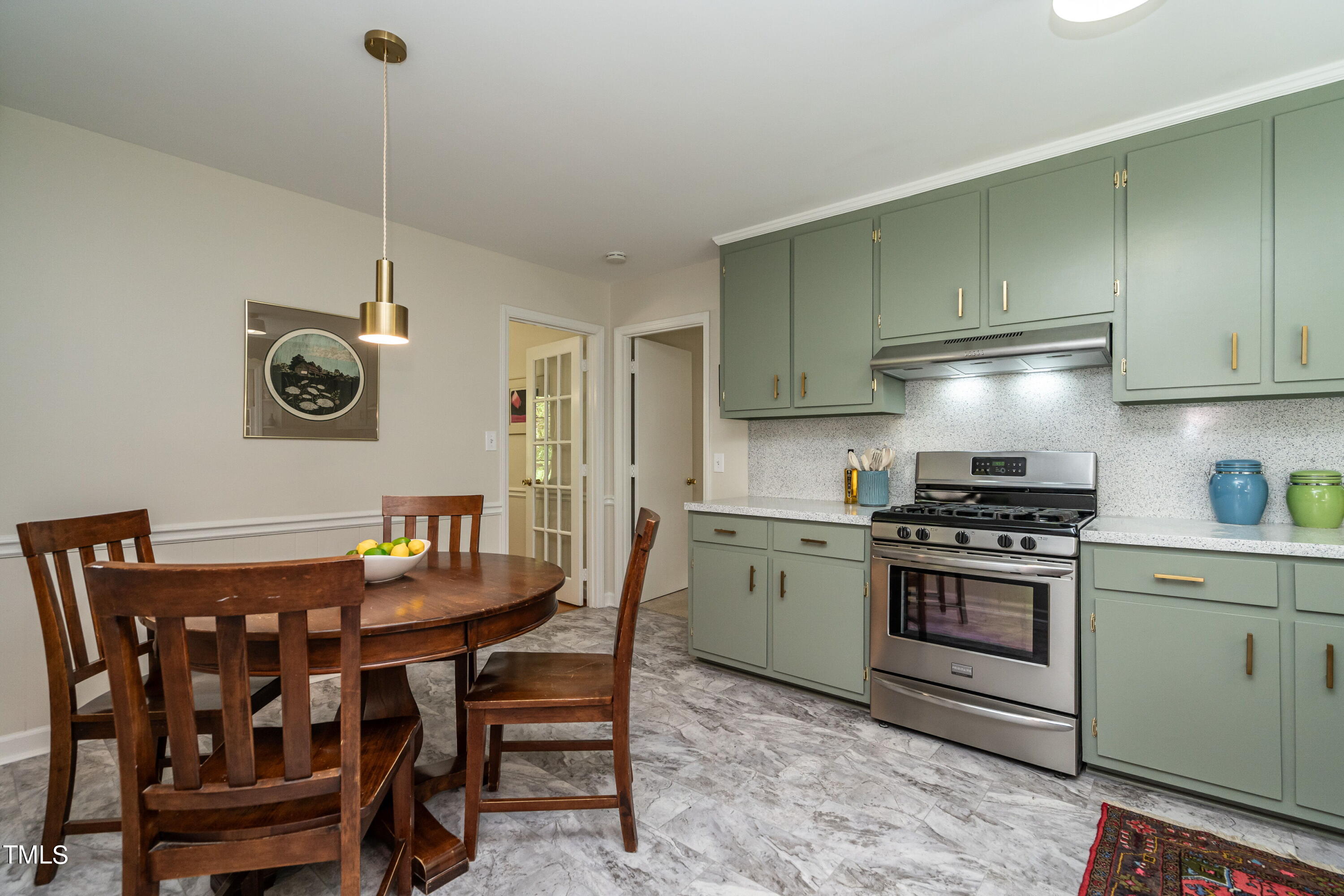 4700 Berini Drive Durham, NC 27705 - Photo 15 of 30 a kitchen with stainless steel appliances granite countertop a dining table chairs stove and white cabinets