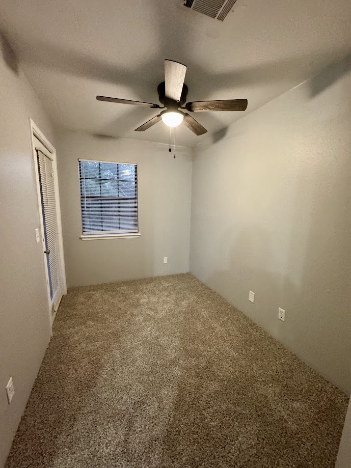 1305 West Villa Maria Road, Unit C107 Bryan, TX 77801 - Photo 16 of 19 en empty room with windows and ceiling fan