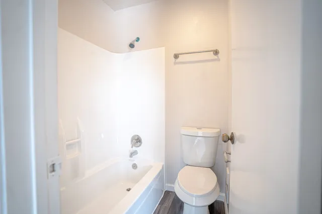 a white toilet sitting next to a bathroom sink and tub