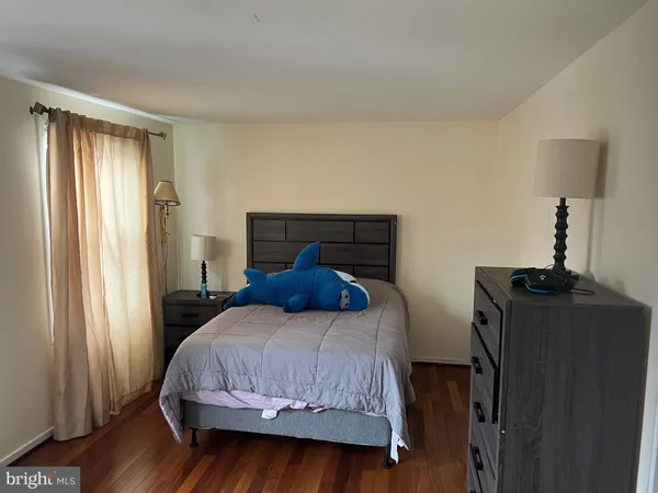 a bedroom with a bed window and wooden floor