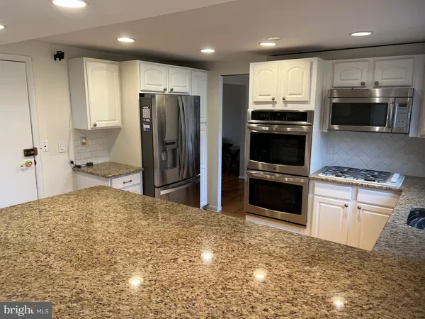 a kitchen with stainless steel appliances granite countertop a refrigerator sink and cabinets