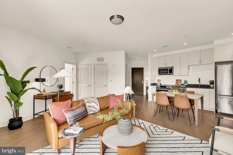 a living room with lots of furniture kitchen view and a dining table