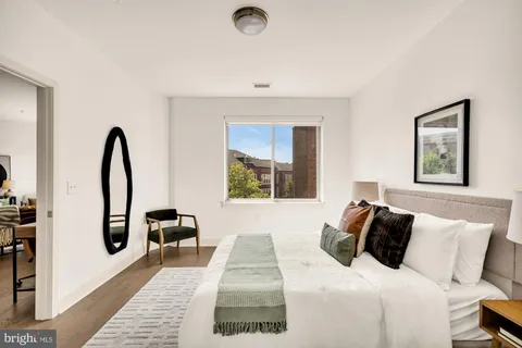 a bedroom with a bed and a large window