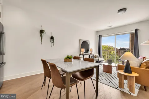 a dining room with furniture a rug and wooden floor