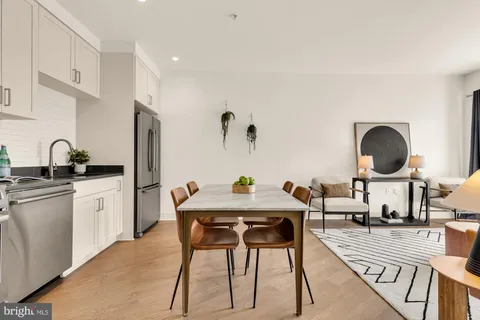 a kitchen with stainless steel appliances a dining table and chairs