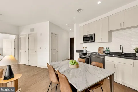 a kitchen with granite countertop a stove a sink a kitchen island with a dining table and chairs