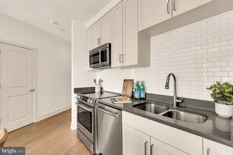 a kitchen with stainless steel appliances granite countertop a sink and a stove