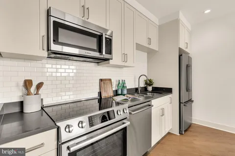 a kitchen with stainless steel appliances granite countertop a stove microwave and sink