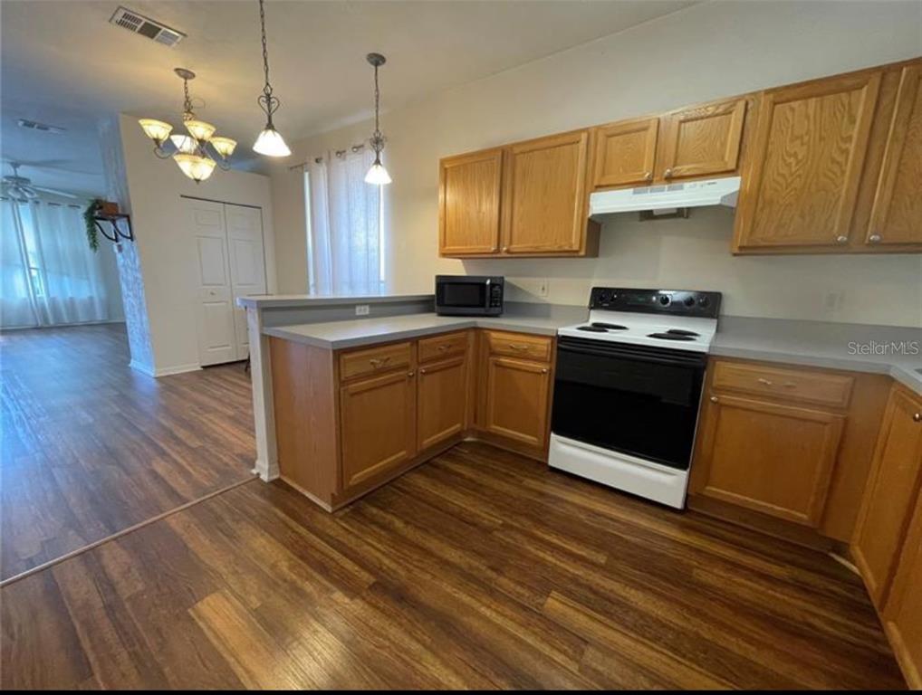 3860 Southwest 20th Avenue, Unit 1801 Gainesville, FL 32607 - Photo 4 of 19 a kitchen with stainless steel appliances granite countertop a sink a stove a refrigerator and island with wooden floor