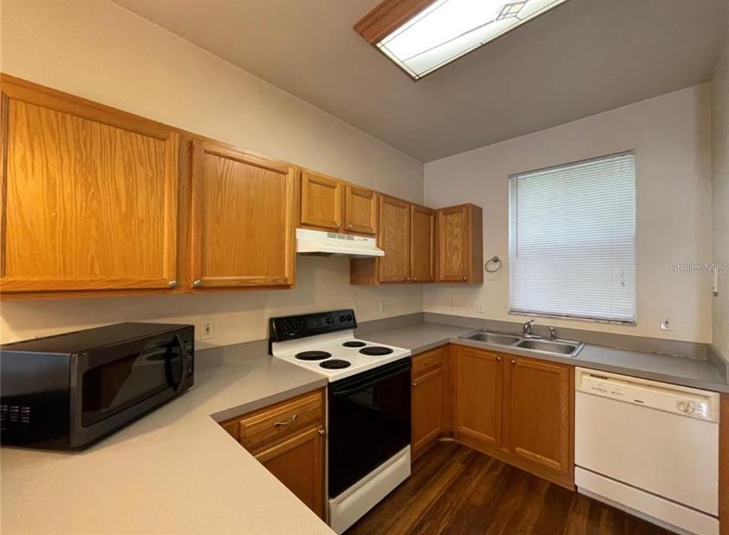 3860 Southwest 20th Avenue, Unit 1801 Gainesville, FL 32607 - Photo 5 of 19 a kitchen with granite countertop a sink cabinets stainless steel appliances and a window
