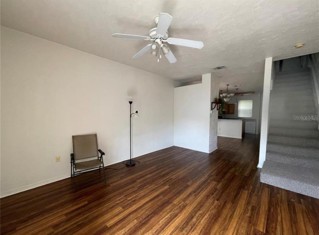 3860 Southwest 20th Avenue, Unit 1801 Gainesville, FL 32607 - Photo 7 of 19 a view of an empty room with wooden floor and a ceiling fan