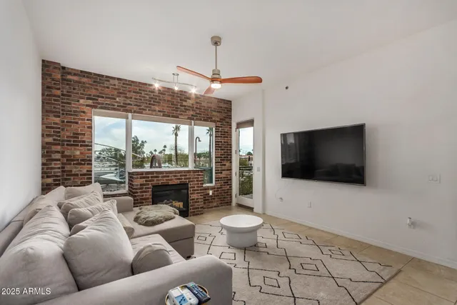 a living room with furniture a flat screen tv and a floor to ceiling window