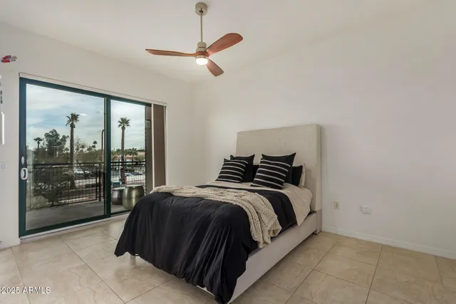 a spacious bedroom with a bed and glass door
