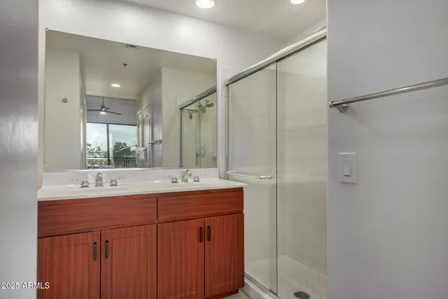 a bathroom with a double vanity sink mirror and shower