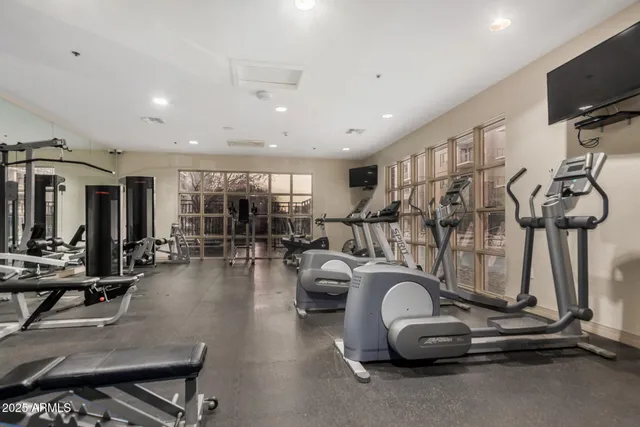 a room with gym equipment and large mirror