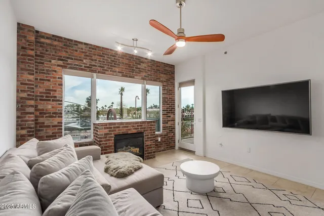 a living room with furniture a flat screen tv and a floor to ceiling window