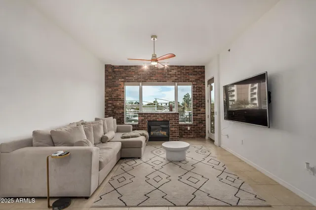 a living room with furniture a flat screen tv and a chandelier