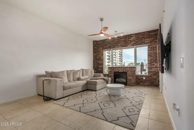 a living room with furniture a fireplace and a floor to ceiling window