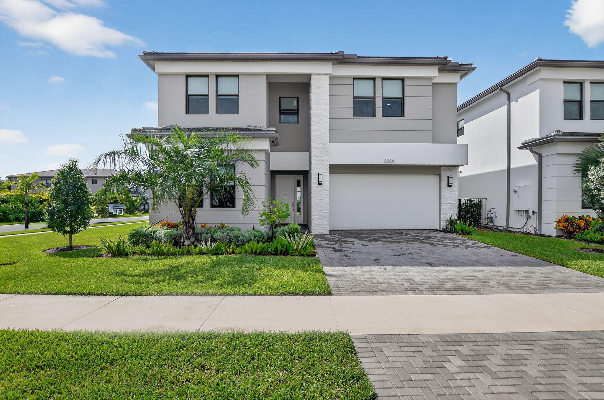 8284 Royal County Down Road Boca Raton, FL 33434 - Photo 2 of 121 a front view of a house with a yard and potted plants