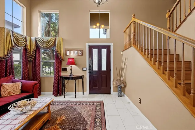 a living room with furniture kitchen view and a wooden floor