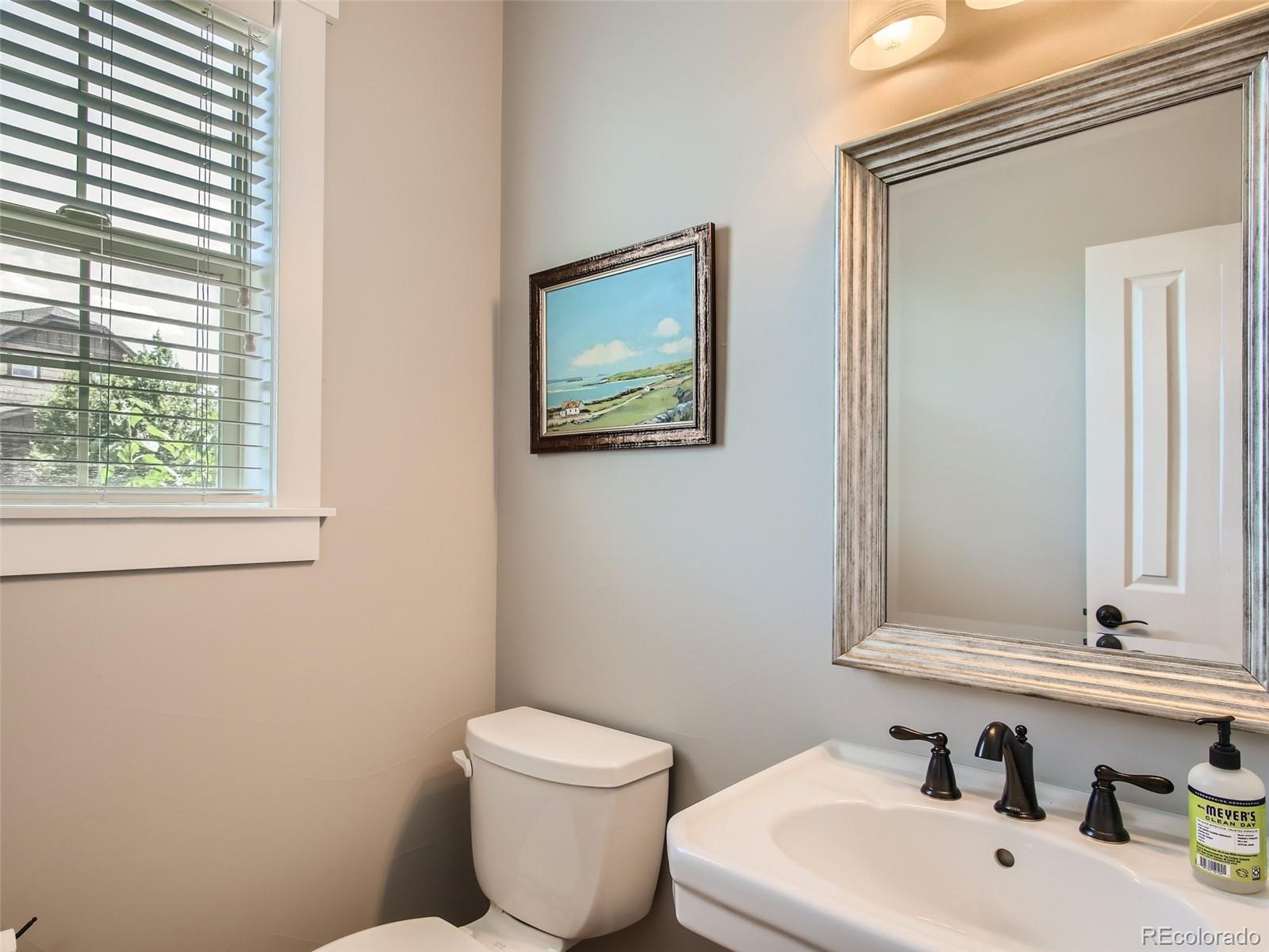 303 Alton Way Denver, CO 80230 - Photo 12 of 35 a bathroom with a toilet a sink and mirror
