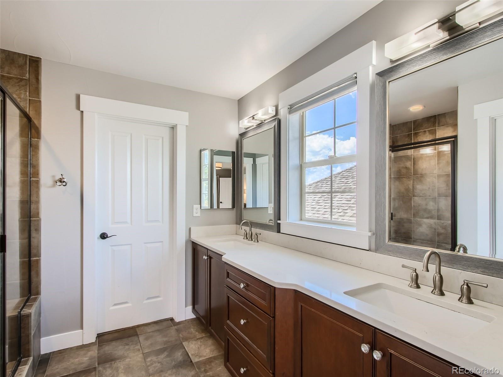 303 Alton Way Denver, CO 80230 - Photo 16 of 35 a bathroom with a sink double vanity and a mirror