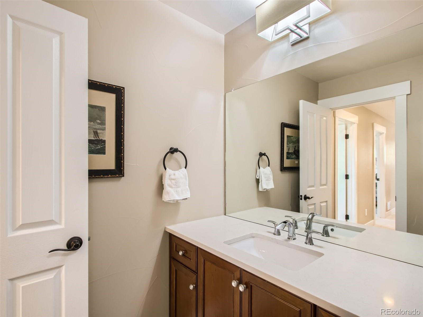 303 Alton Way Denver, CO 80230 - Photo 19 of 35 a bathroom with a double vanity sink and a mirror
