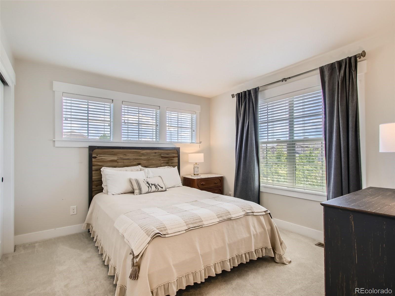 303 Alton Way Denver, CO 80230 - Photo 21 of 35 a bedroom with a large bed and a large window