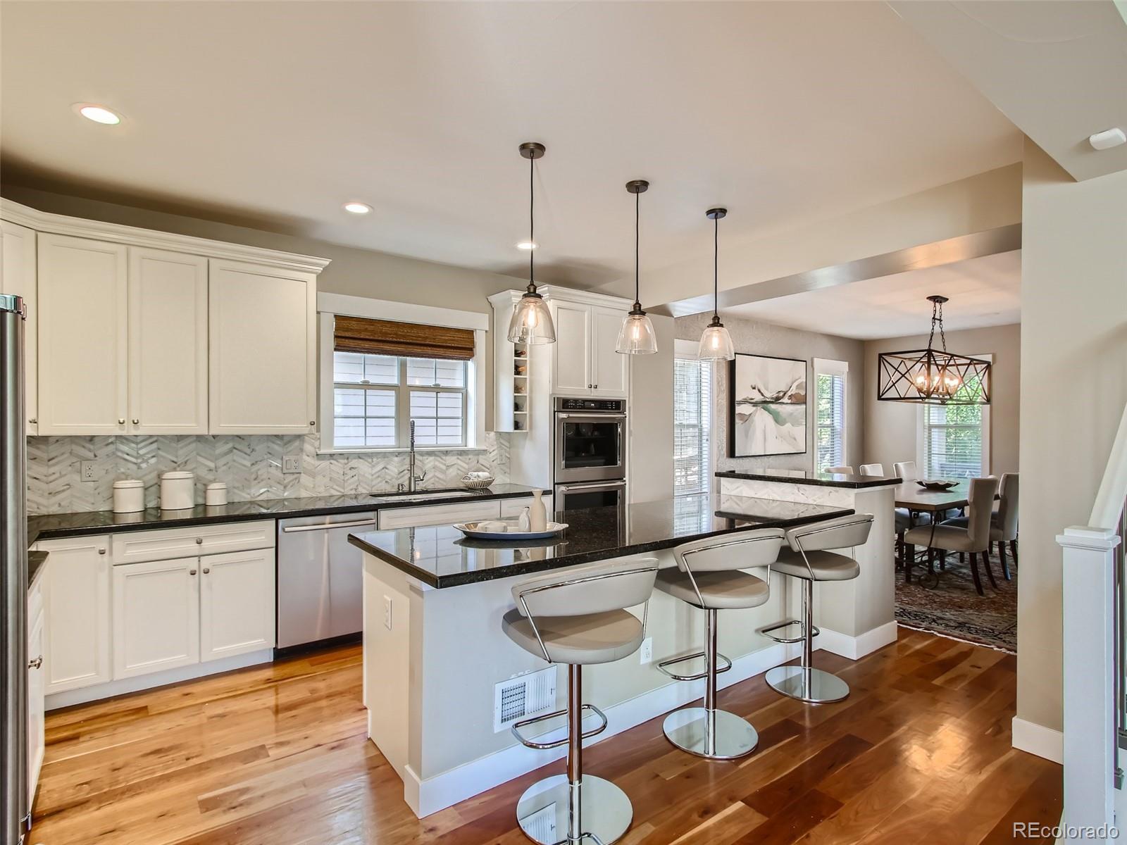 303 Alton Way Denver, CO 80230 - Photo 3 of 35 a kitchen with granite countertop a stove a sink and a refrigerator