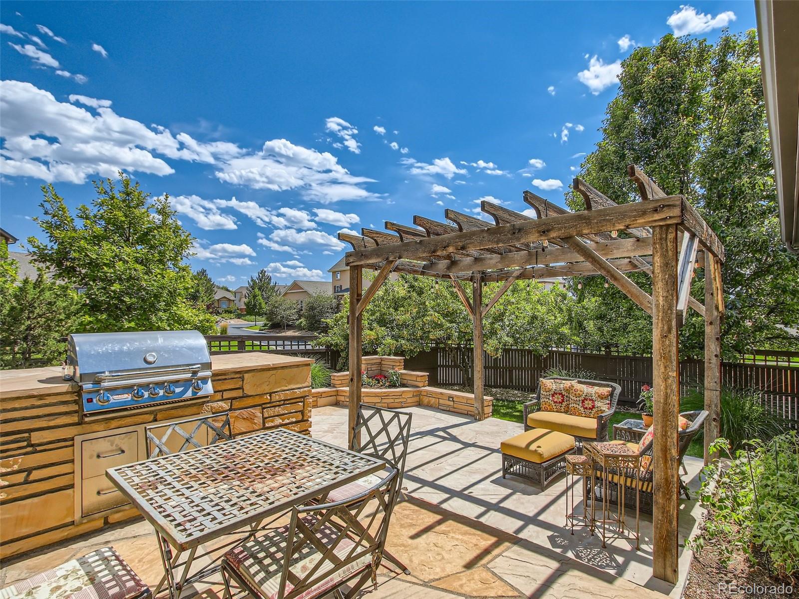 303 Alton Way Denver, CO 80230 - Photo 6 of 35 a view of a patio with dining table and chairs with wooden floor and fence