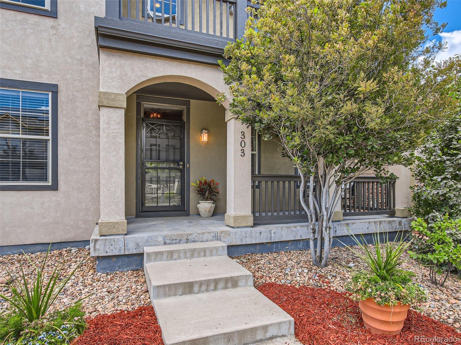 303 Alton Way Denver, CO 80230 - Photo 7 of 35 a front view of a house with a garden