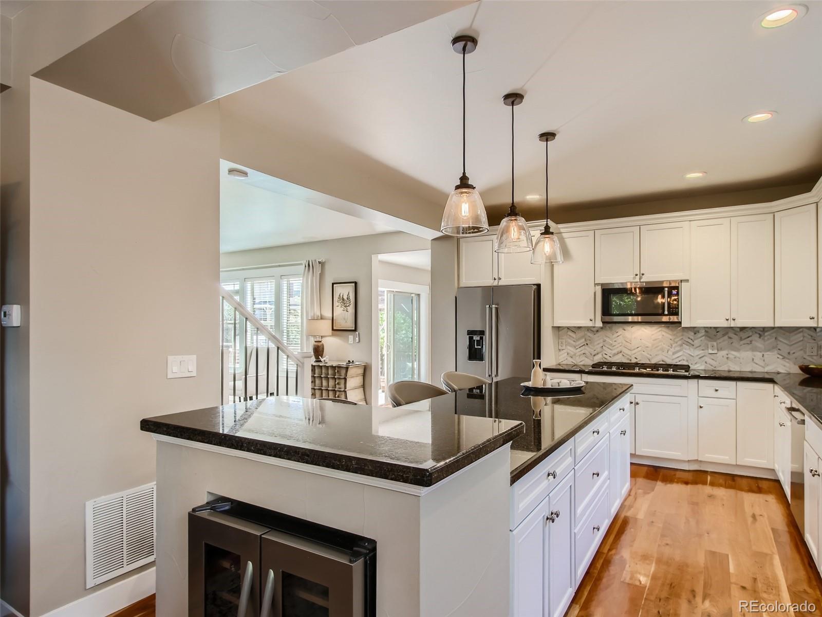 303 Alton Way Denver, CO 80230 - Photo 10 of 35 a kitchen with granite countertop a sink stove and refrigerator
