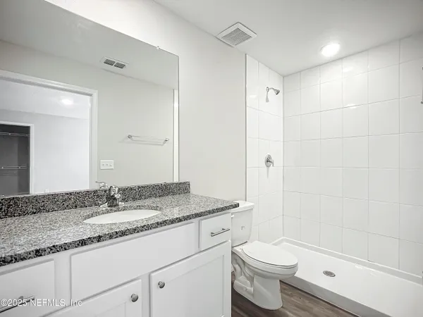 a bathroom with a granite countertop sink toilet and shower