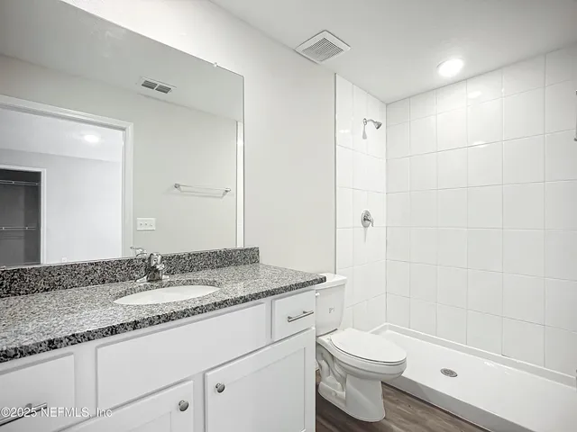 a bathroom with a granite countertop sink toilet and shower