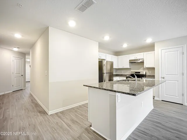 a kitchen with stainless steel appliances granite countertop a refrigerator and a sink