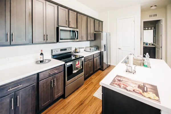 a kitchen with stainless steel appliances granite countertop a sink stove and refrigerator