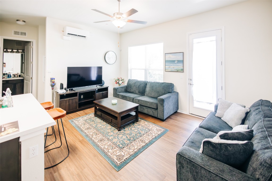 8601 West Gate Boulevard, Unit 4203 Austin, TX 78745 - Photo 4 of 15 Living area with a wall mounted AC, ceiling fan, and light wood-style floors